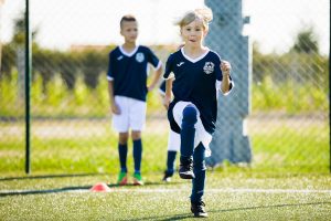 ćwiczenia wytrzymałościowe chłopców podczas letniego obozu piłkarskiego